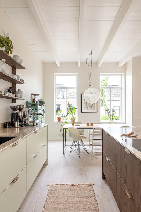 Eethoek met witte balken, een grote hanglamp en een houten tafel