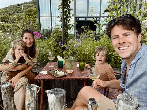 Eline met haar gezin aan een tuintafel tussen de bloemen
