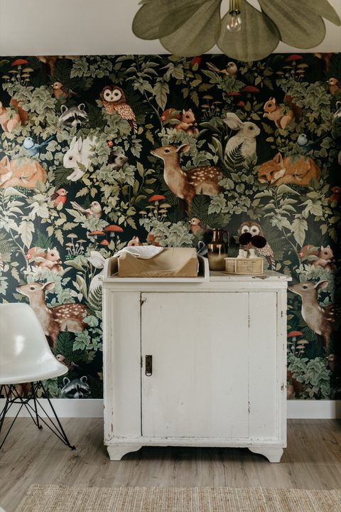 Kinderkamer met bosbehang en een witte vintage commode